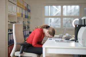 a woman sitting at a desk who is frustrated with her work