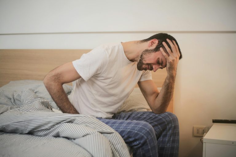 A man sitting down who is managing a headache